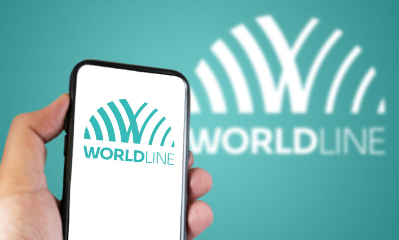 Hand holding a smartphone with the Worldline logo on the screen